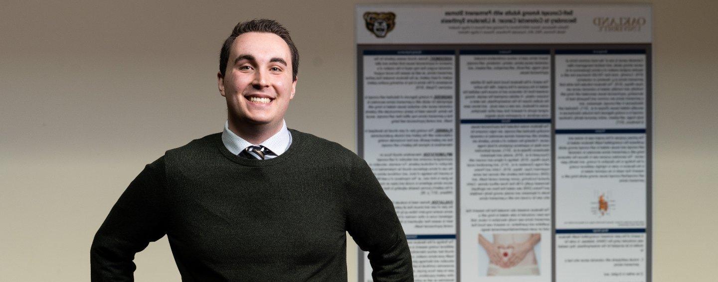 man in front of research poster